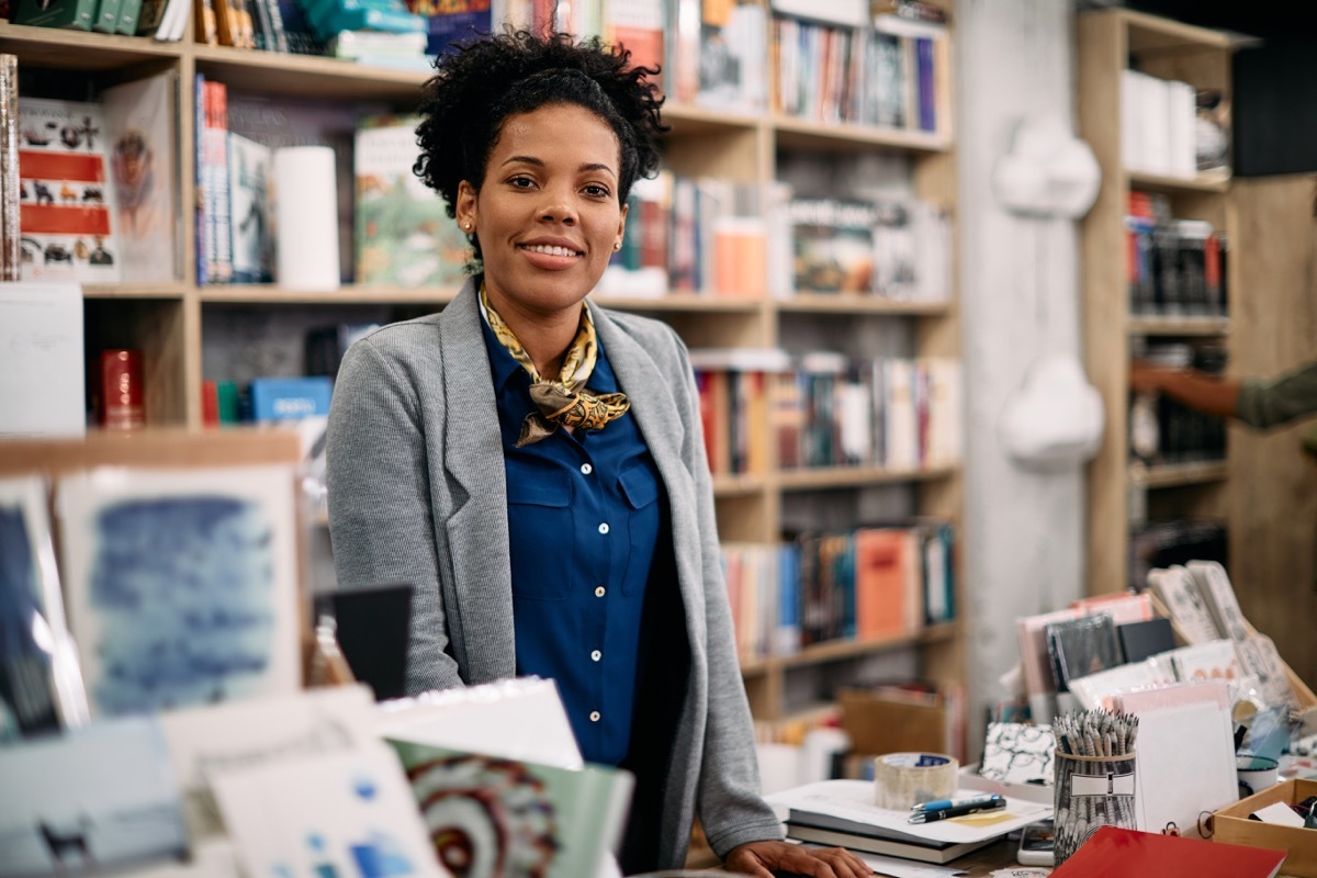 saleswoman at bookstore checkout looking at camera.