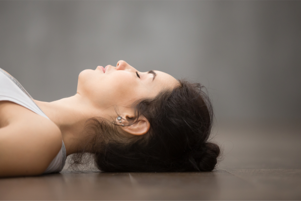 Woman lying on floor with eyes closed