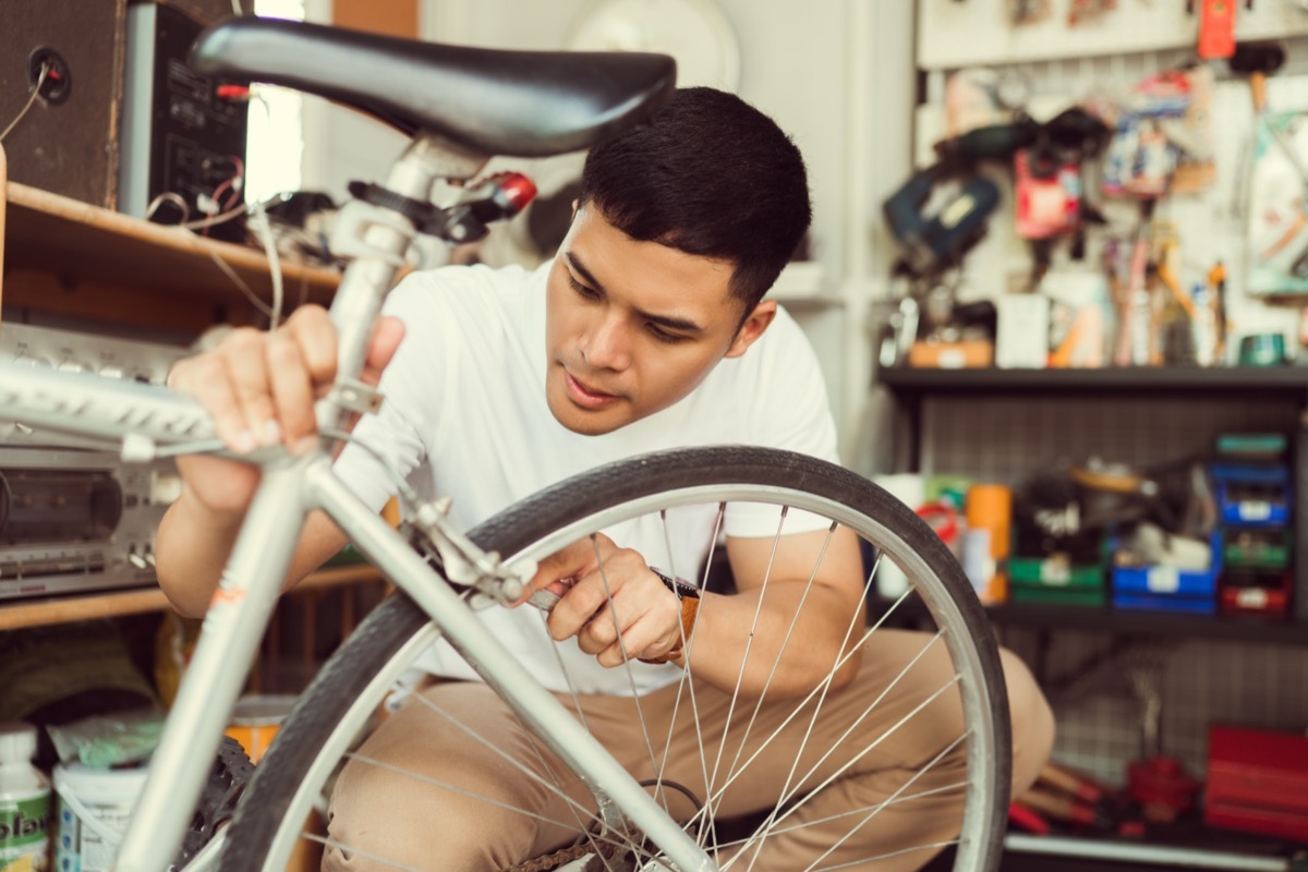 young man repairing bike tire