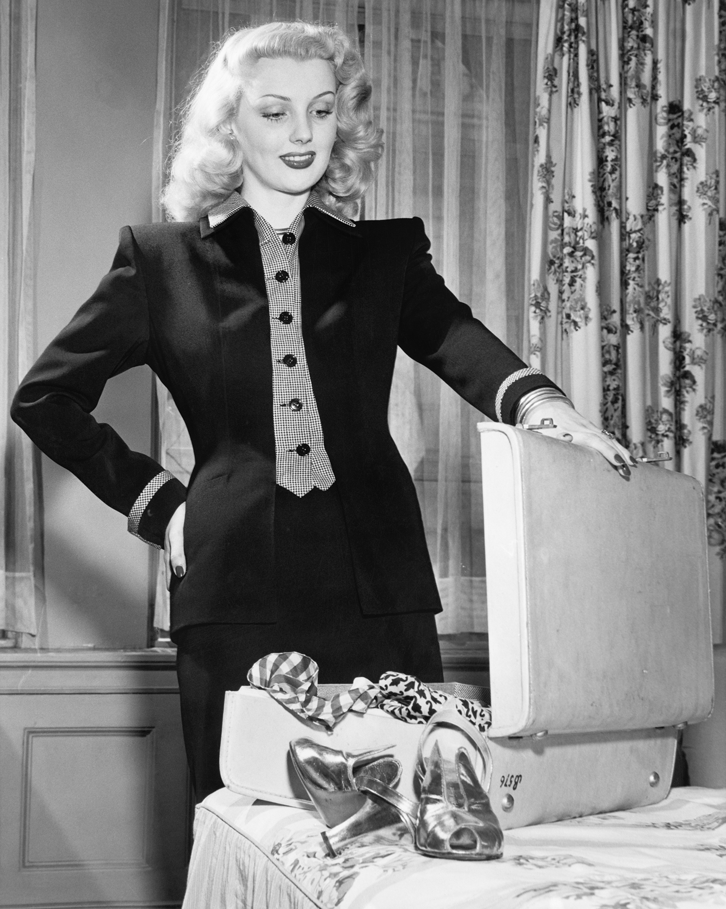 a 1940s woman opens a suitcase