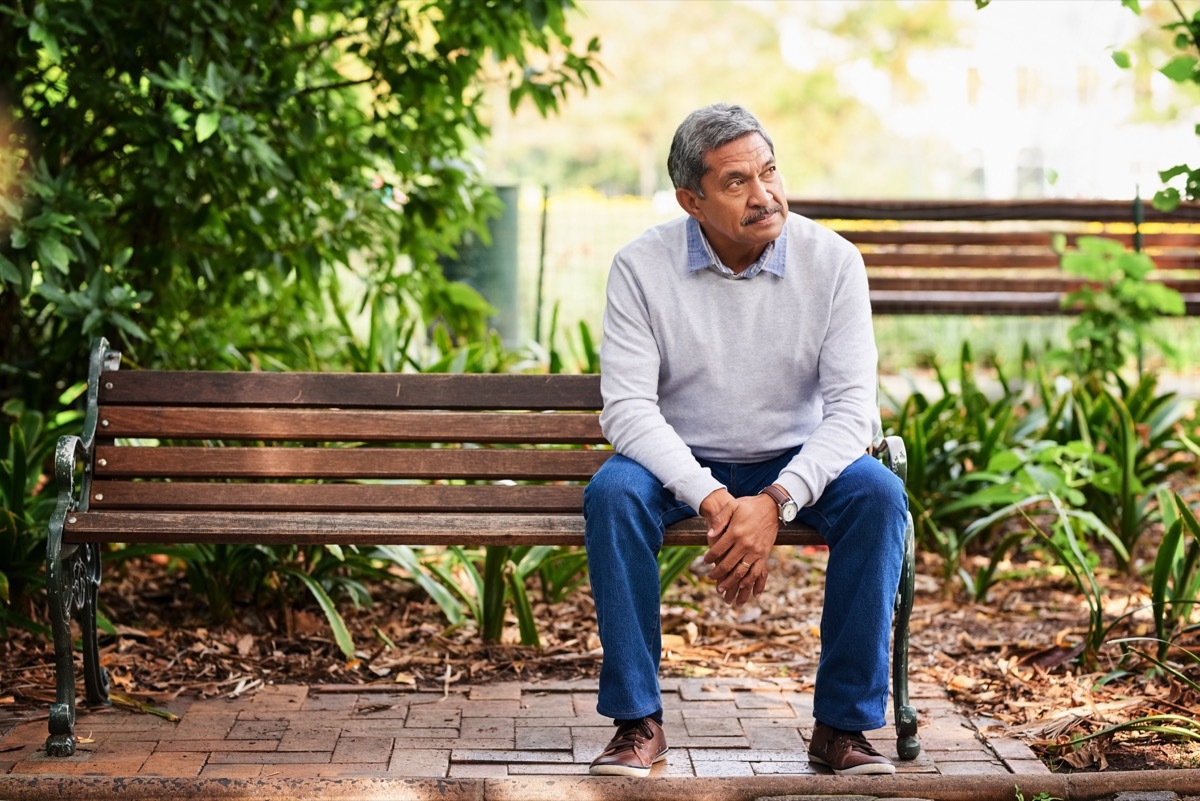 skeptical man sitting outside looking off into distance
