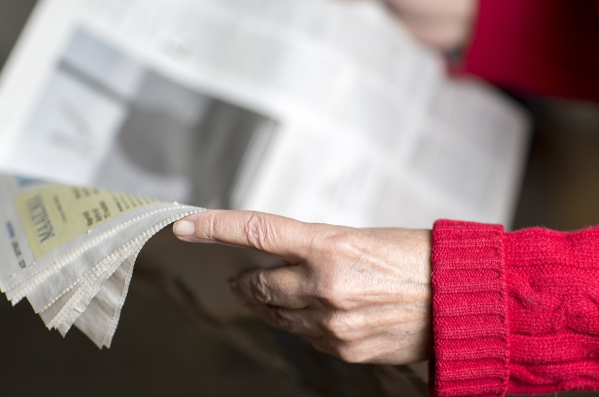 older woman reading the newspaper, paper routes