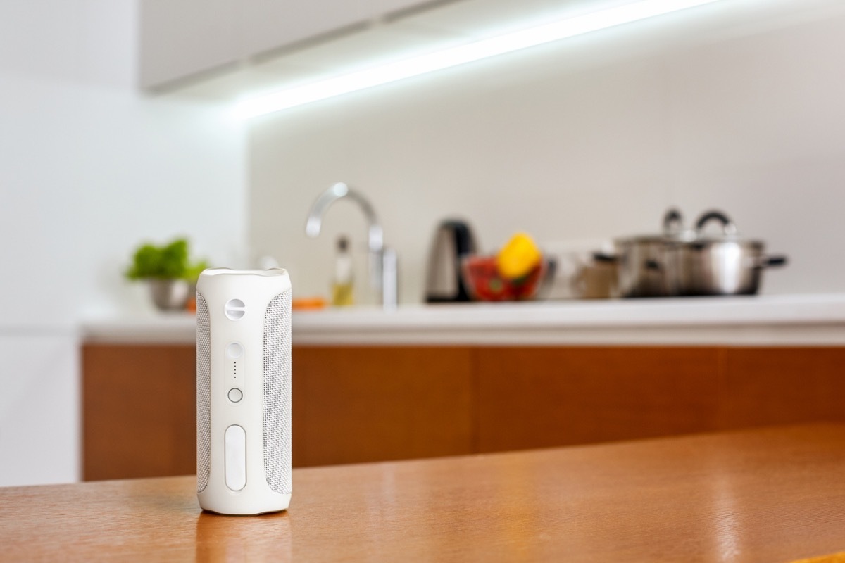 Smart wireless speaker isolated on table at kitchen at home close-up blurred background