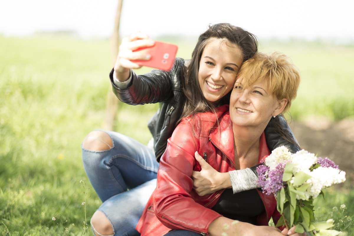 Mother and daughter taking a selfie with flowers