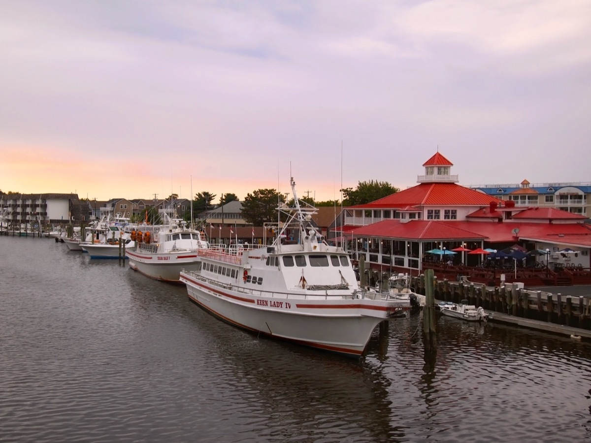 LEWES, DELAWARE - AUGUST 29, 2017: Tour boats and fishing boats are moored in the harbor at sunset in Lewes, Delaware, a United States eastern shore town rich in Civil War history. - Image