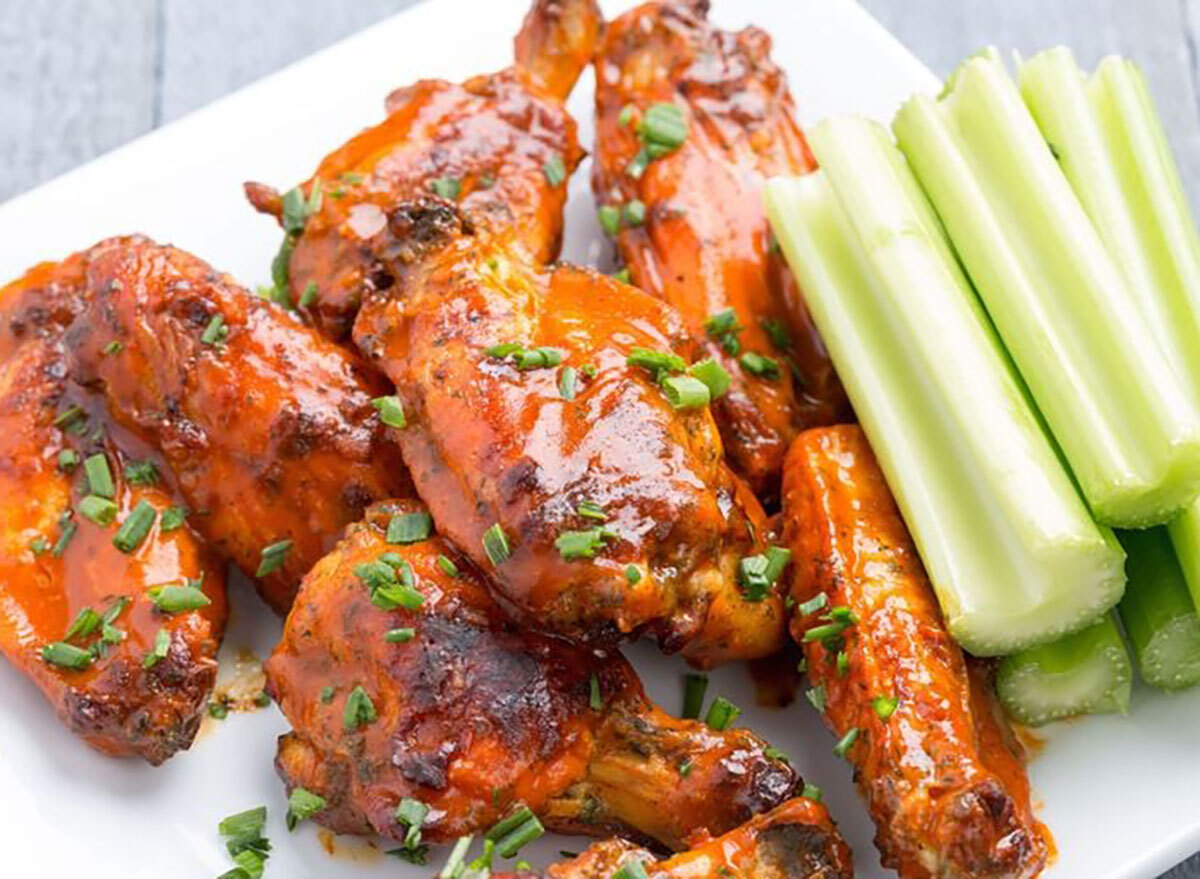 plate of buffalo wings with scallions