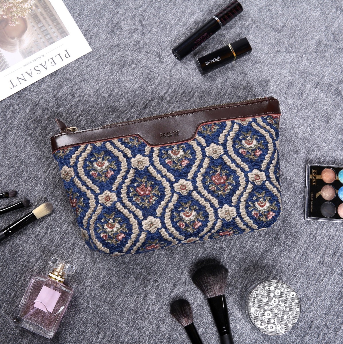 Blue vintage print bag surrounded by beauty products