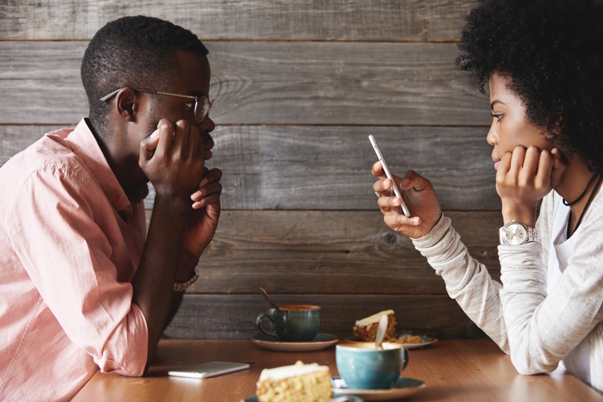 woman on the phone while a man is talking to her, stress signs