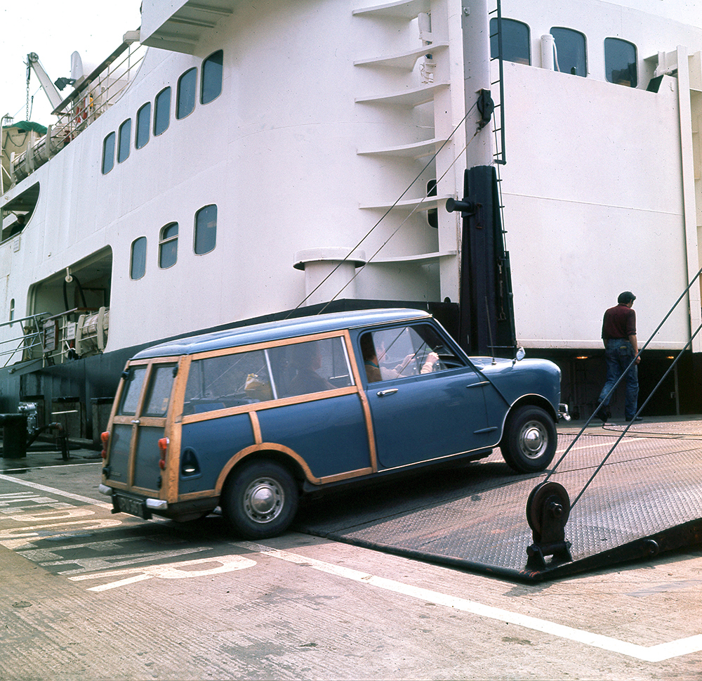 a car drives on a ferry in the 1960s