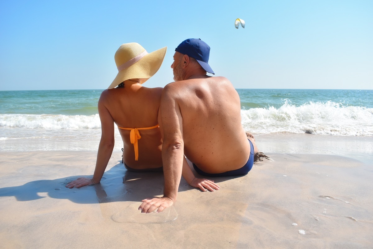 Older couple sitting in sand