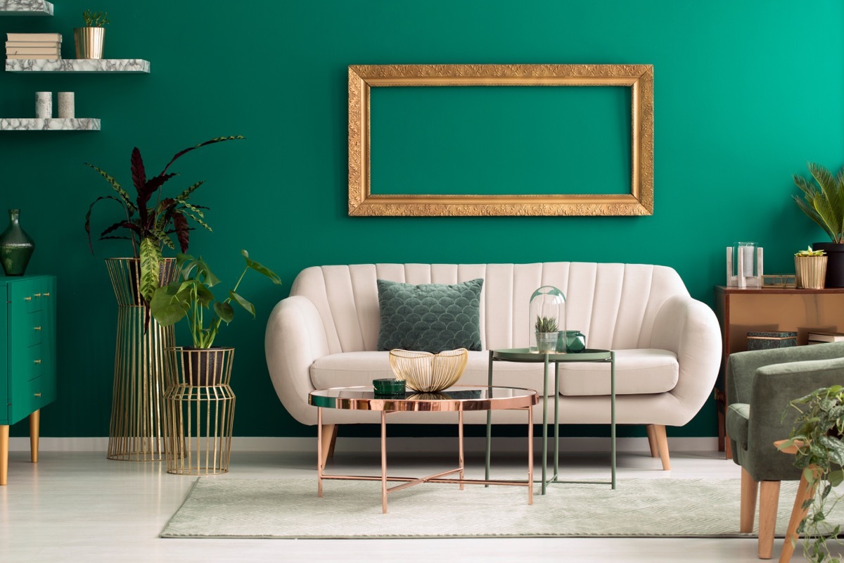 rounded beige sofa against green wall