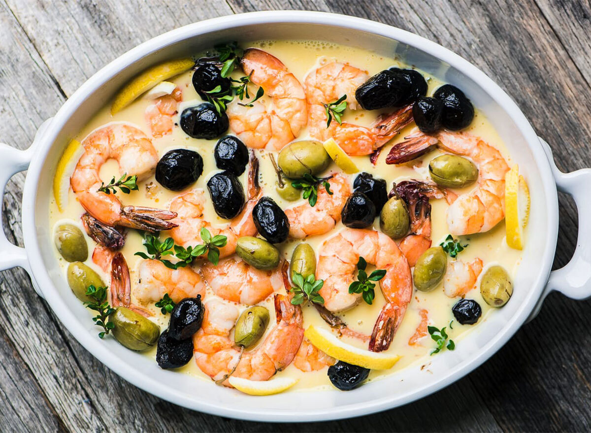 shrimp and olives in oval baking dish with lemon sauce