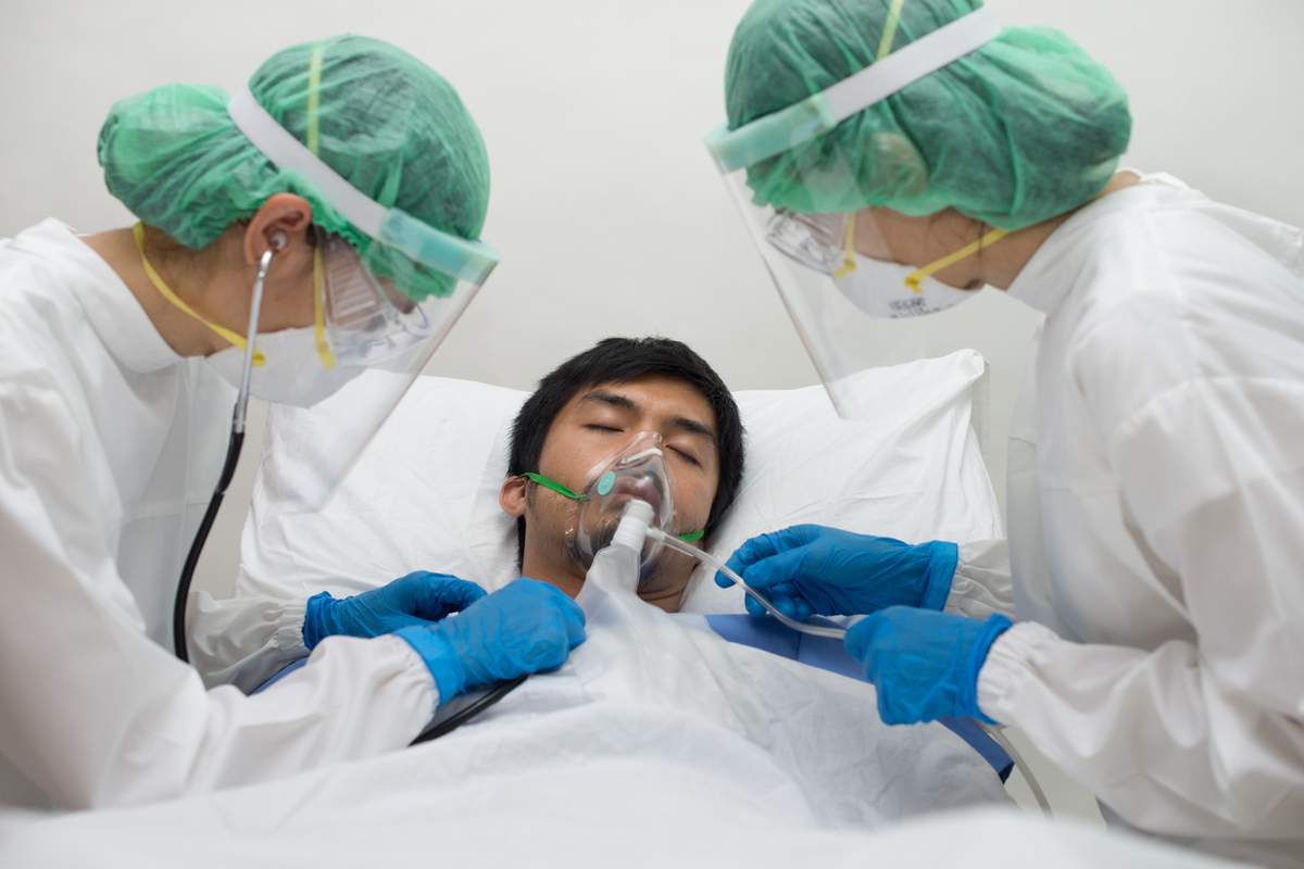 young asian man in hospital with oxygen mask for coronavirus