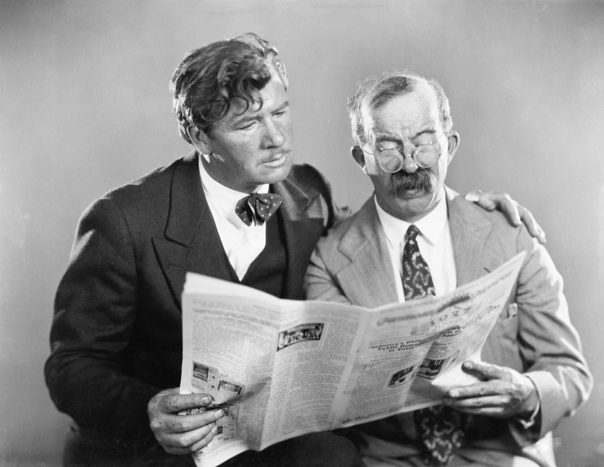 Vintage-looking photo of two men reading a newspaper