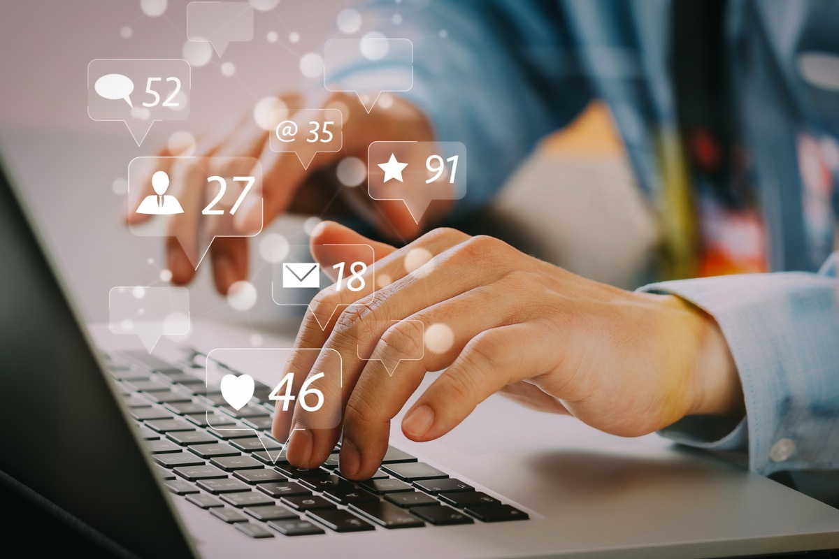 Social media and Marketing virtual icons screen concept.close up of businessman typing keyboard with laptop computer on wooden desk in modern office