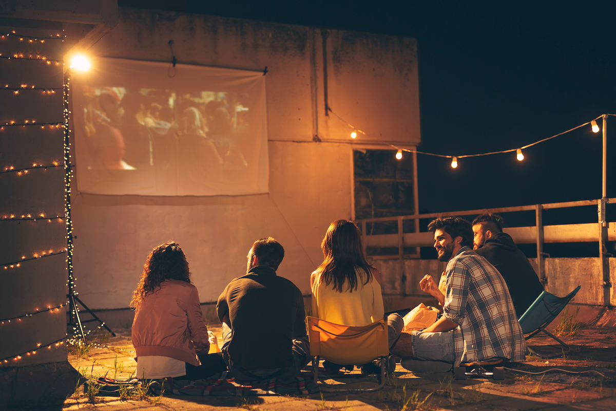 people watching a movie with an outdoor projector