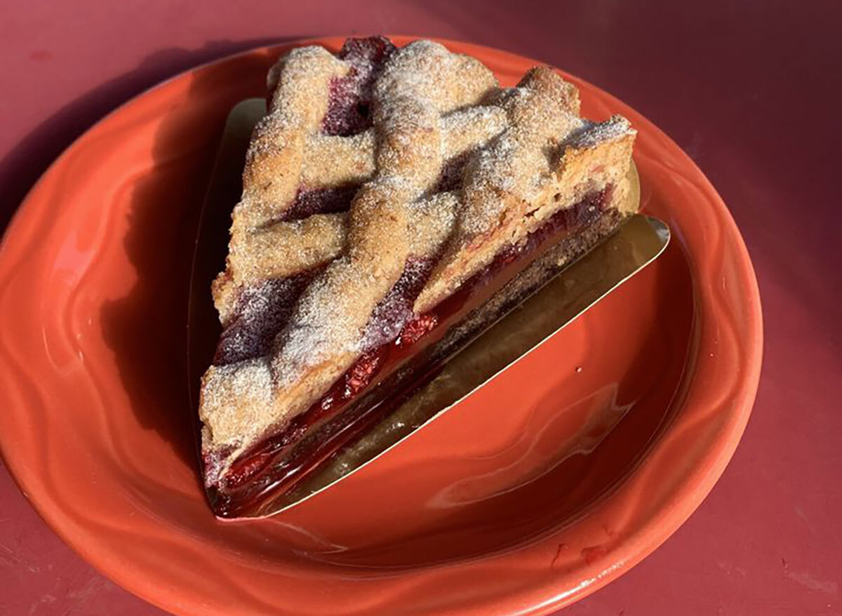 slice of raspberry pie on red plate