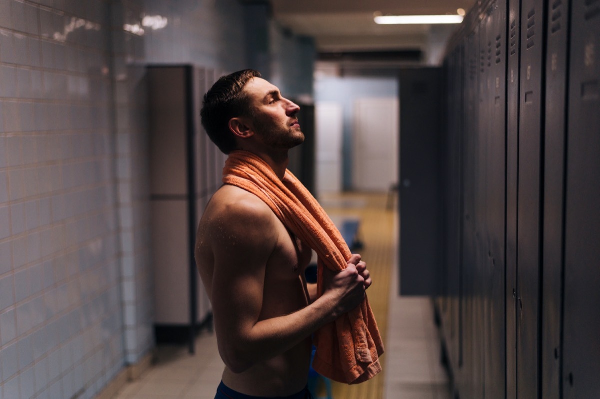 Side view young man swimmer in locker room