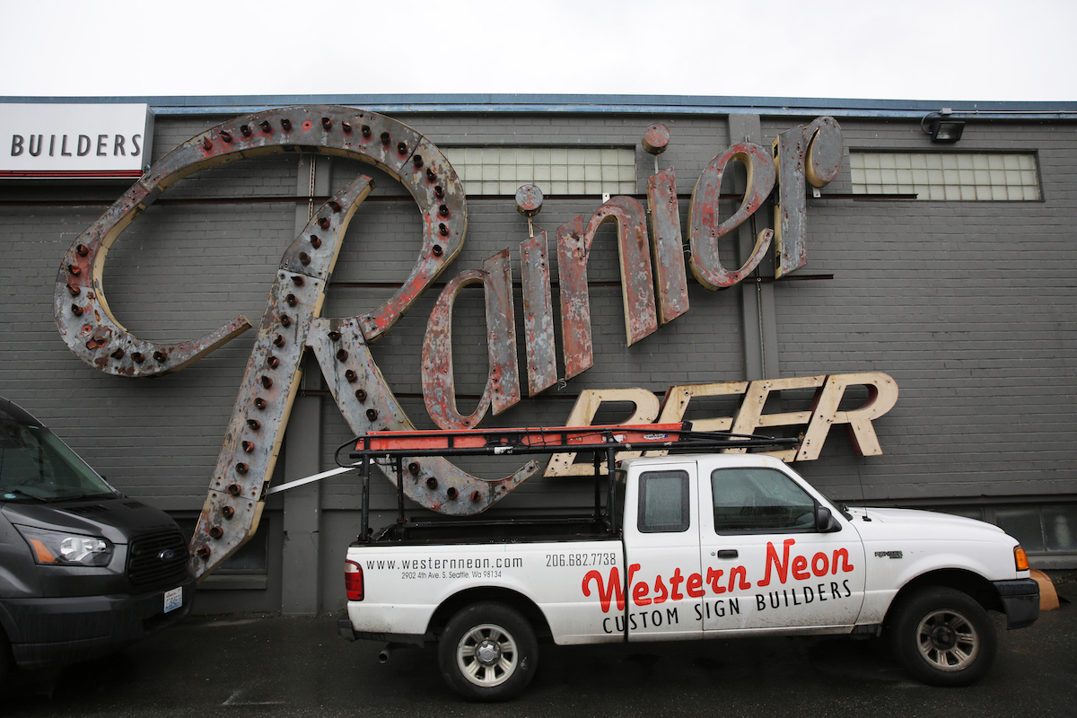 An original Rainier Beer sign hangs on an exterior wall of the Western Neon shop in Sodo.