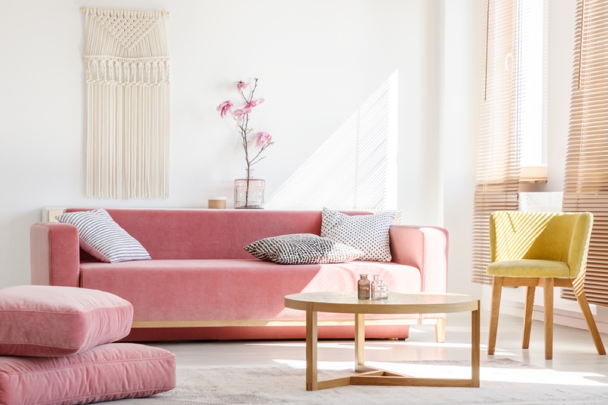 living room with pink couch and ottoman