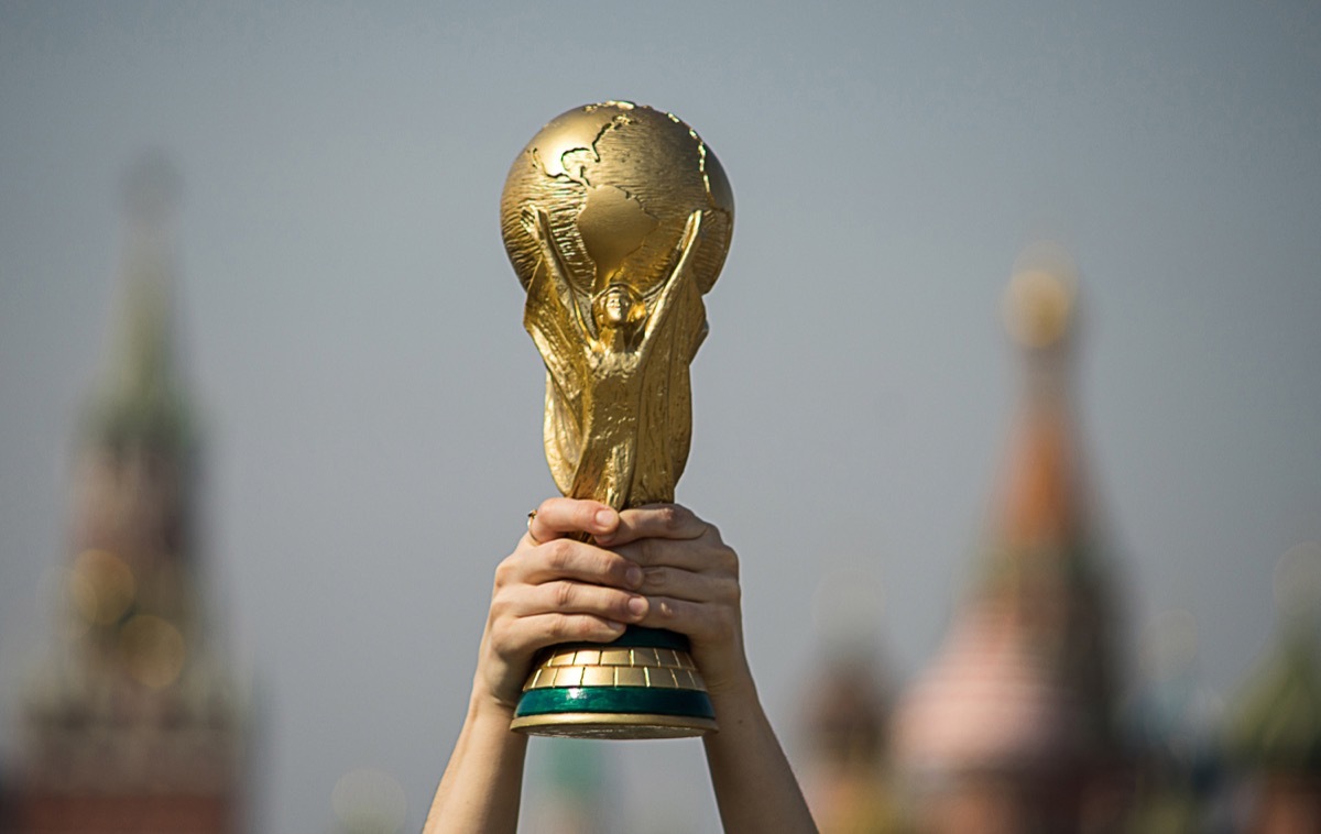 world cup trophy being held in the air