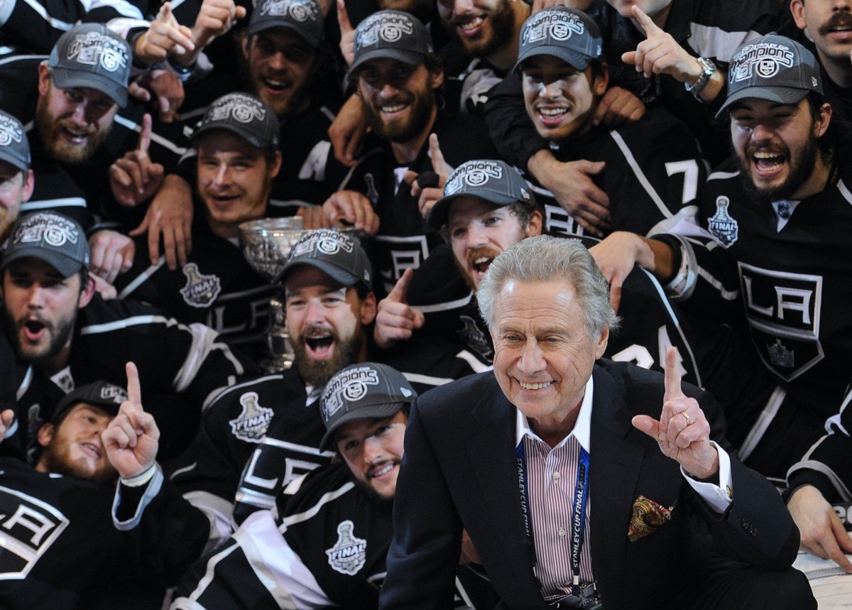 Los Angeles Kings owner Philip Anschutz, right, with his team pose for a group picture after beating the New Jersey Devils 6-1 in game 6 to win the Stanley Cup , Monday, June 11, 2012, in Los Angeles.