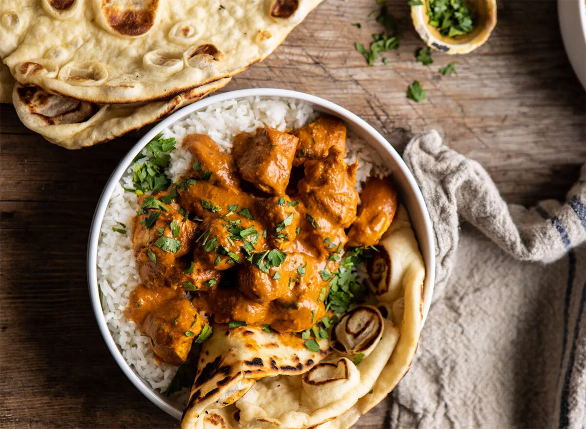 coconut chicken tikka masala in bowl with rice and pita bread