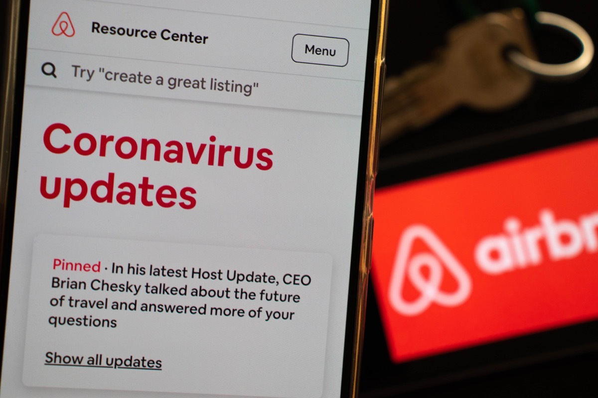 Milan, Italy - 05 16 2020: An Airbnb host is checking last updates on Airbnb app regarding covid-19 coronavirus and its impact on tourism and hospitality policies. Vacation business is in a crisis