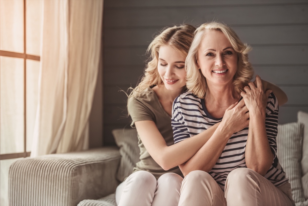 Adult daughter hugging mother smiling