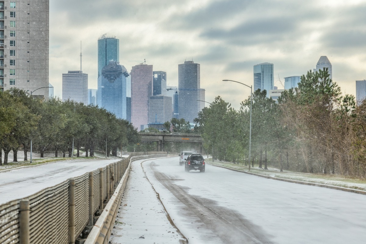 Houston, United States - February 15, 2021: Vehicles navigating the snow and ice on Memorial Drive into downtown Houston as Winter Storm Uri unleashes record cold temperatures in southeast Texas.