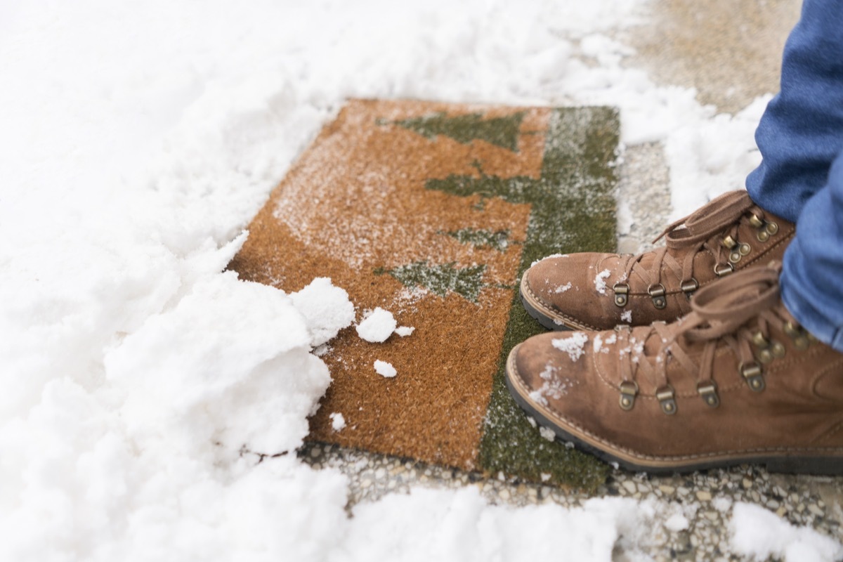 One person standing on a snowy doormat