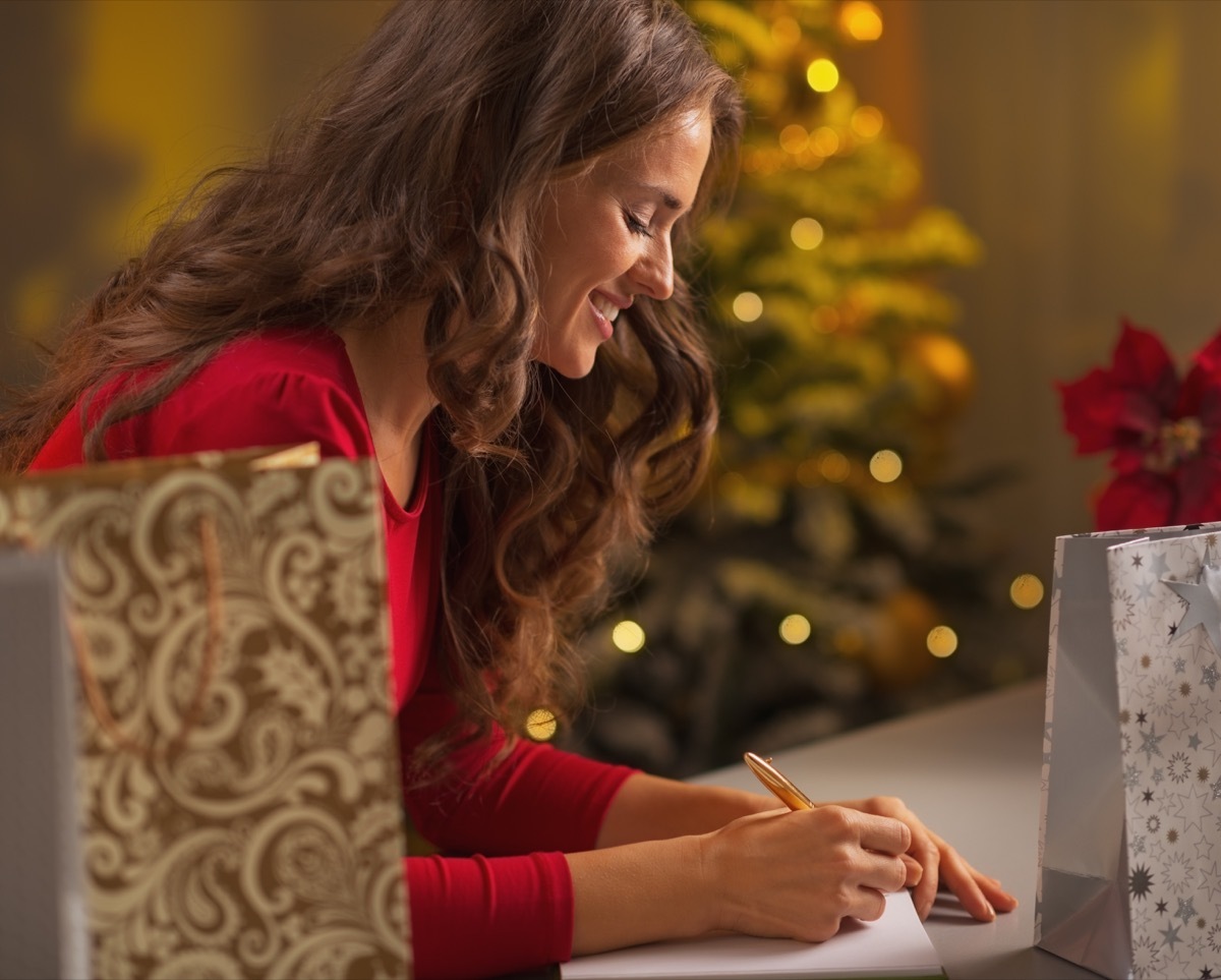 happy woman writing christmas list