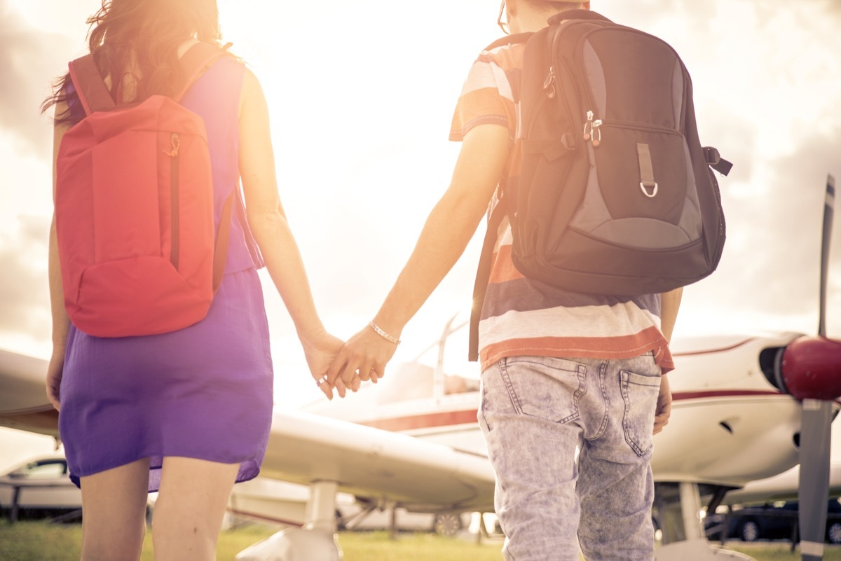 Couple getting on airplane booking cheap flights