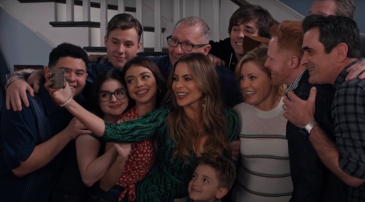 the cast of Modern Family taking a photo together in their final episode