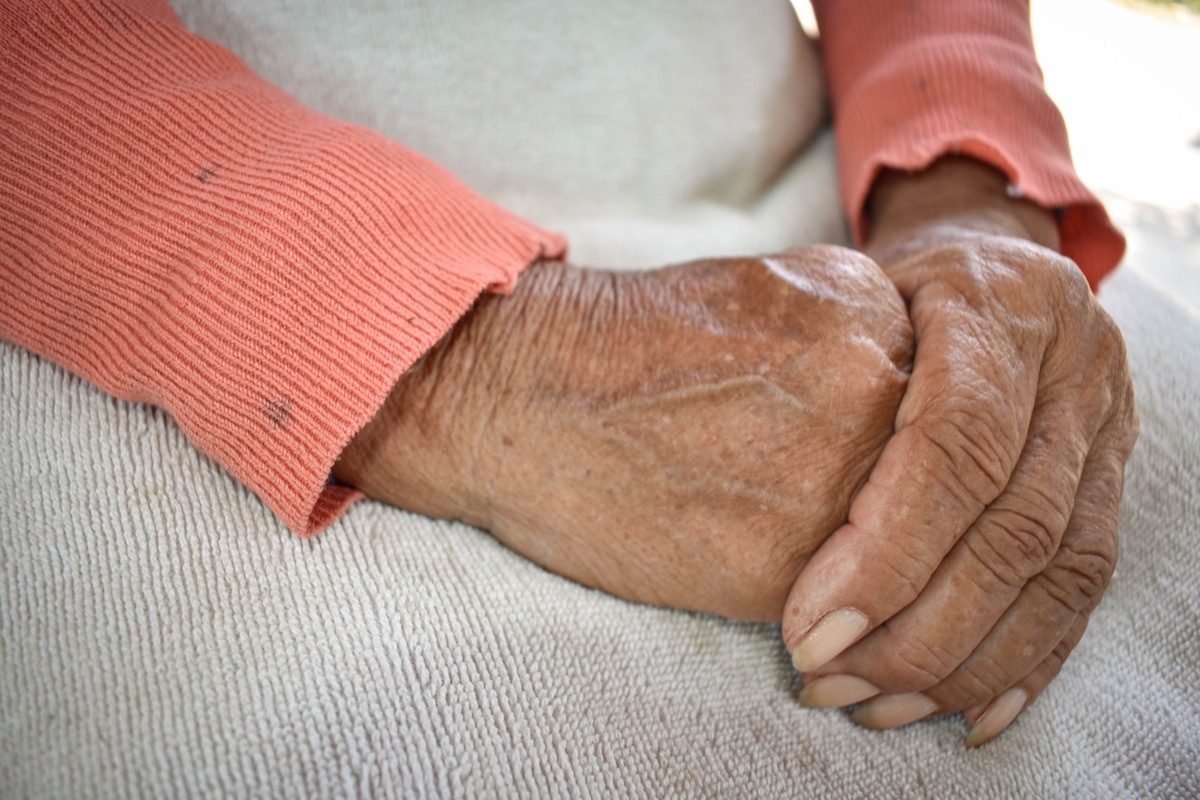 older person with hands in lap