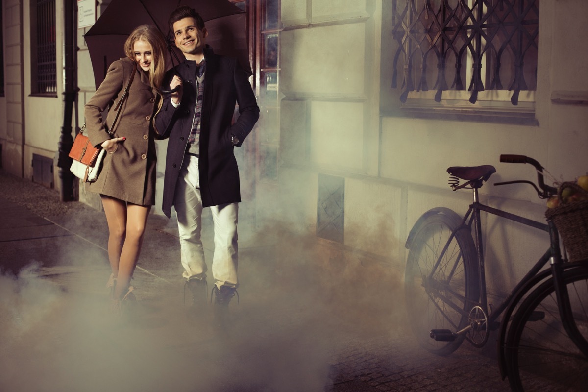 man and woman wearing long coats waking outside after a date