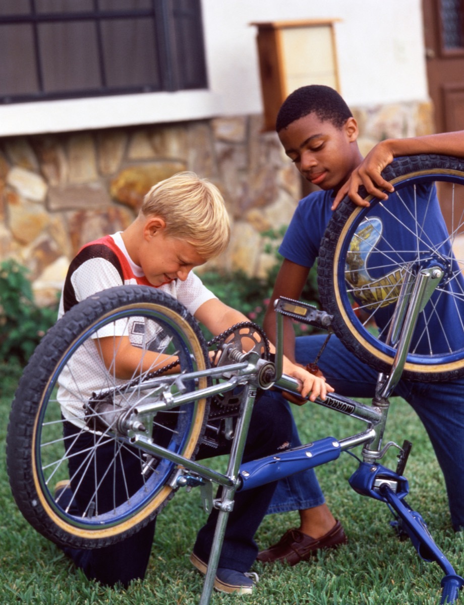 Black and white boy fix bike 1980s