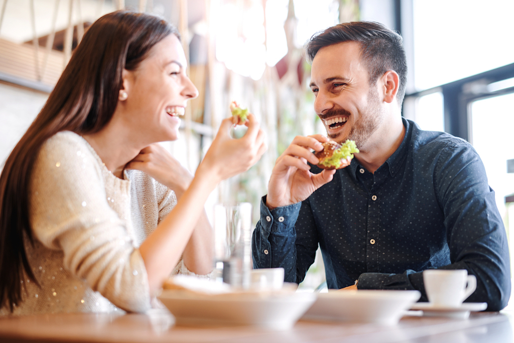 happy couple eating in diner