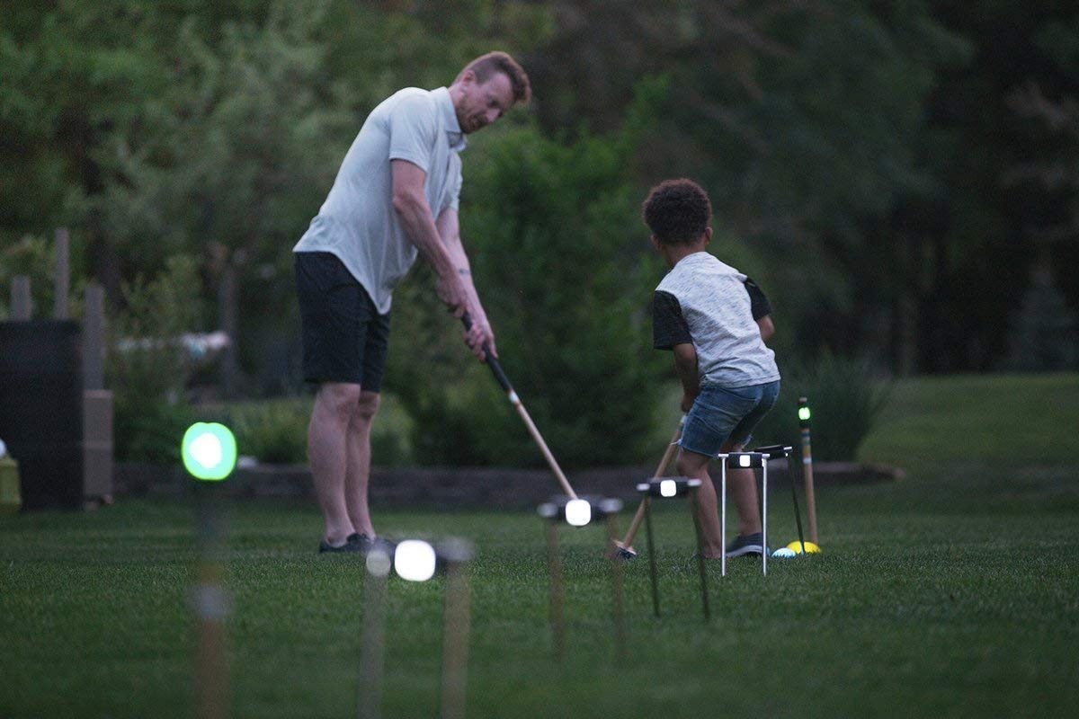 man and son playing light up lawn games