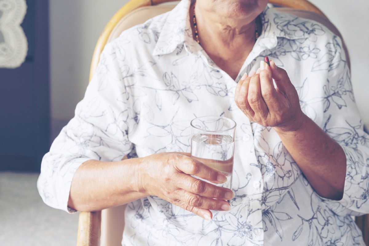 older woman taking medicine, heart risk factors