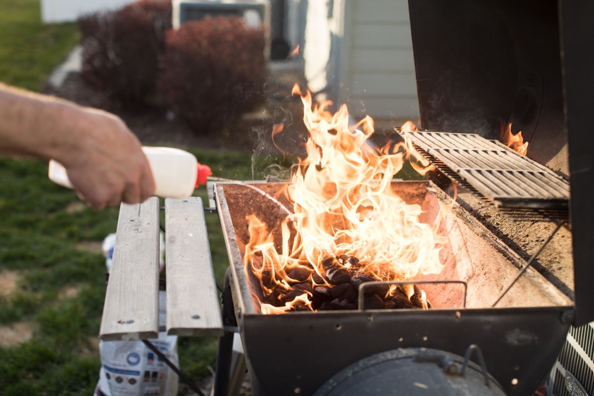 pouring lighter fluid on grill