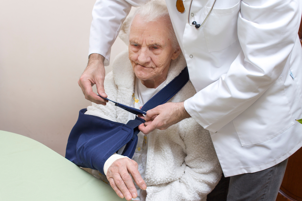 old woman getting a sling for her injury