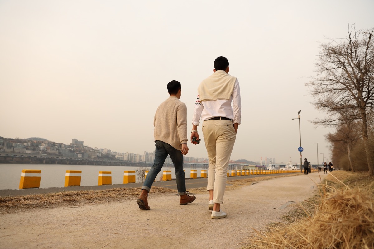 A tall man and a small man are walking in the background of Hannam Bridge and Han river in Sinsa-dong, Gangnam-gu.