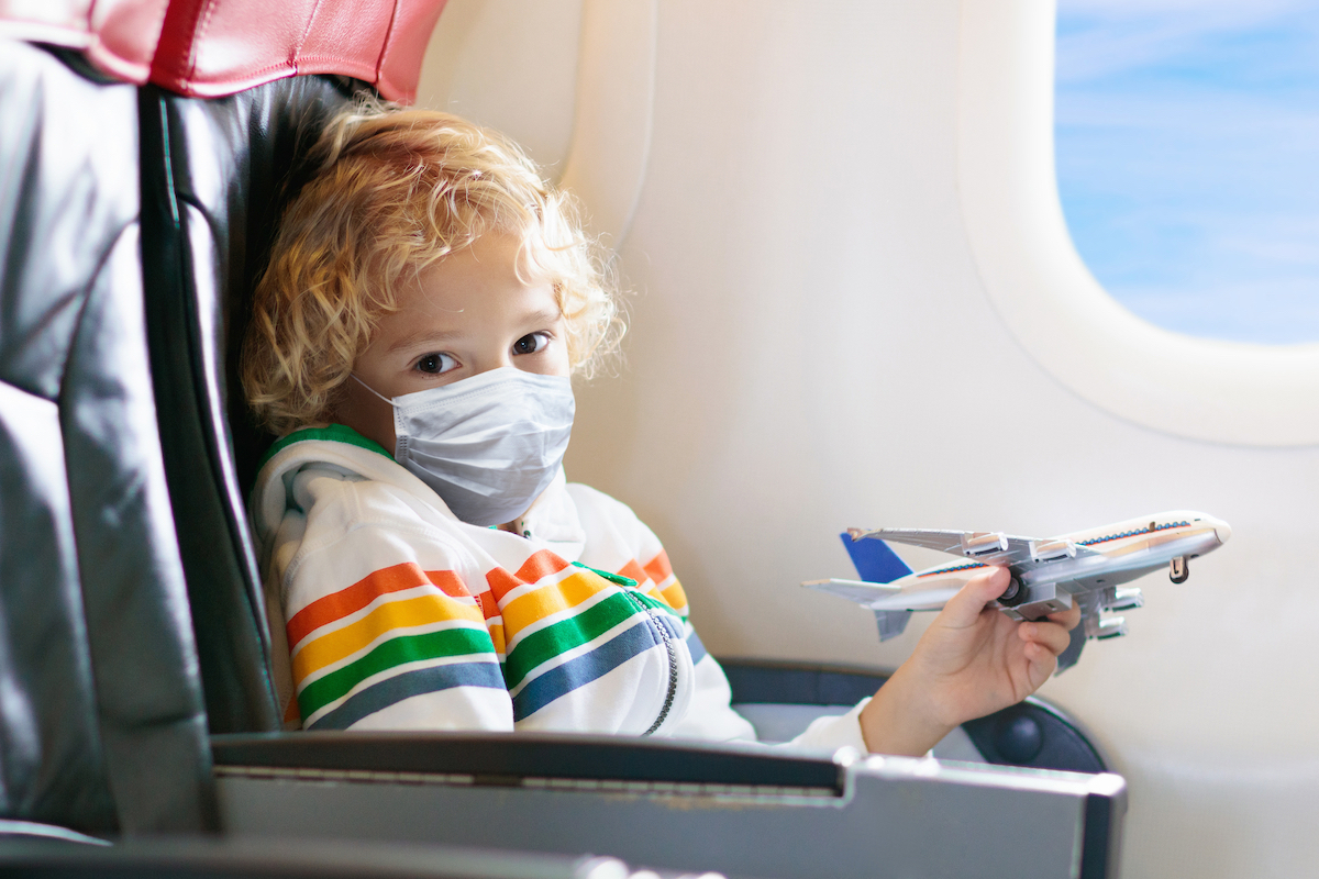 Child in airplane in face mask