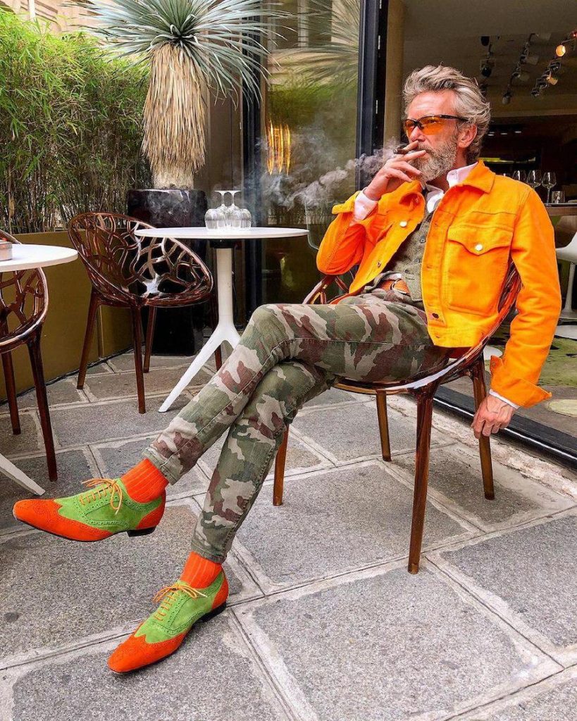 Pierrick makes work Bright orange jacket, tight camo pants, bright orange and green shoes  | 12 Classiest Yet Fun OOTD You’ve Ever Seen From Pierrick Mathon | Her Beauty