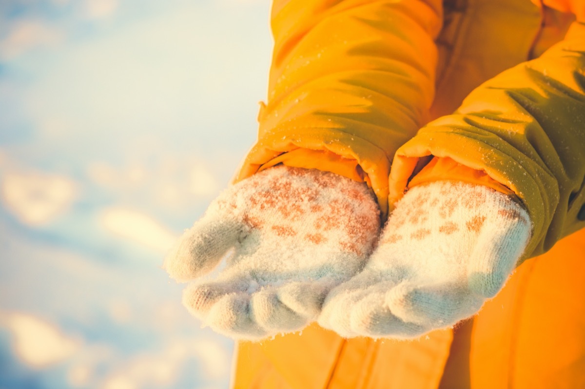 Hands in the ski gloves creates a snowball winter day