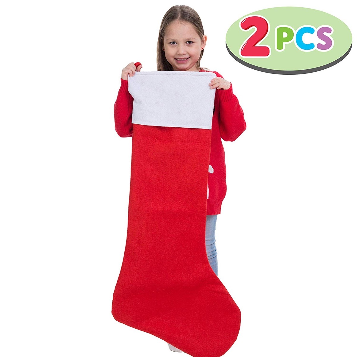 young girl holding up huge red and white stocking
