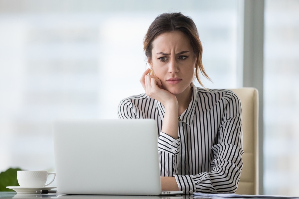woman looking uncertain at her computer