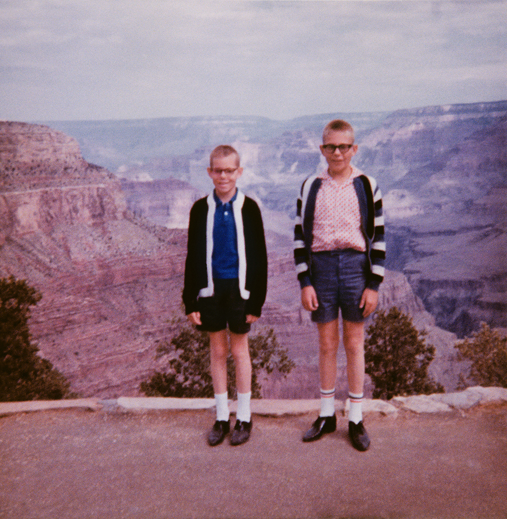 two boys pose in front of the grand canyon