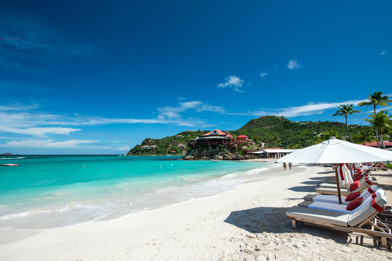 A white sand beach with lounge chairs in St. Barths